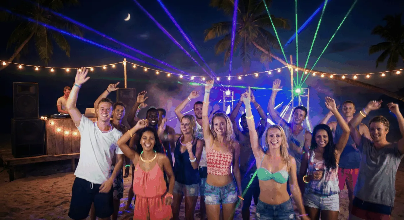 Party crowd dancing on beach under moonlight with tropical island nightlife atmosphere